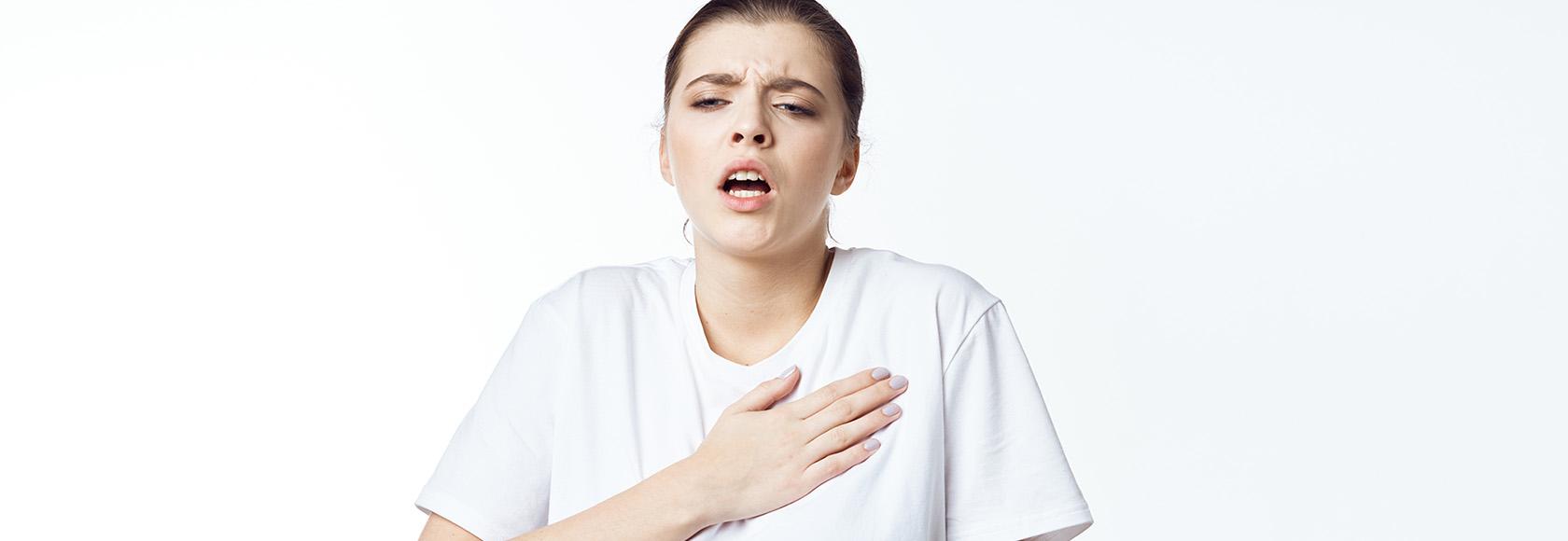 Młoda kobieta trzyma rękę na klatce piersiowej