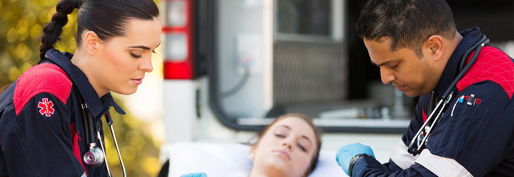 Dwoje ratowników z chorą na noszach