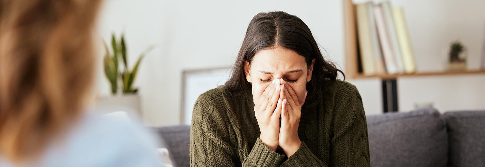 Młoda kobieta trzyma twarz w dłoniach