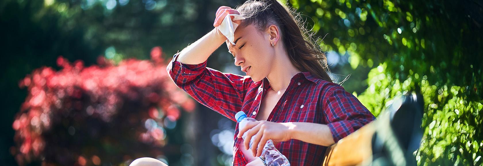 kobieta siedzi na ławce i ociera twarz chustką