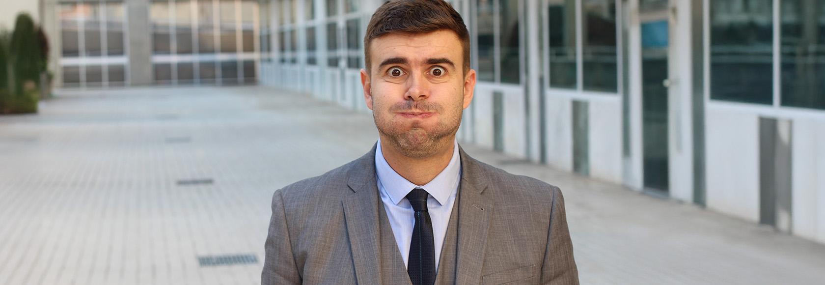 Mężczyzna w garniturze wydyma policzki.