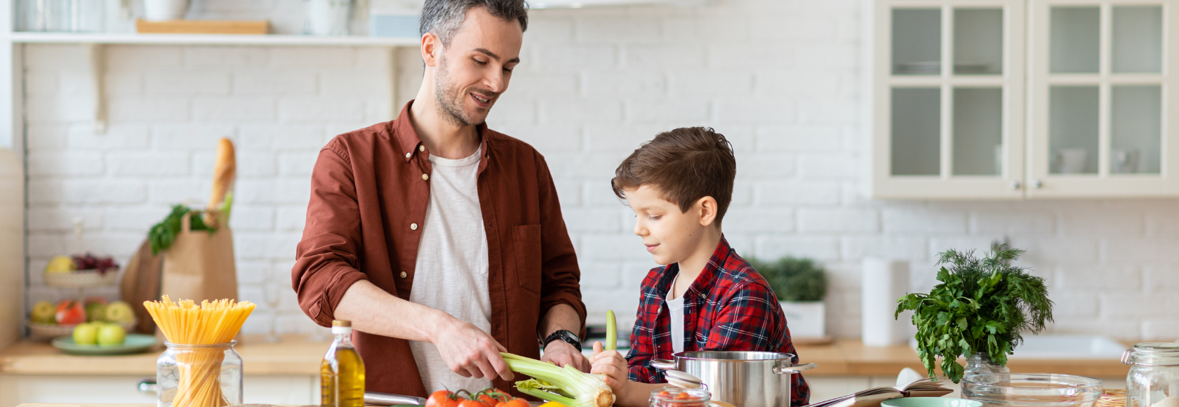 mężczyzna i chlopiec gotują w kuchmni
