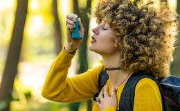 Dziewczyna z kręconymi włosami trzyma inhalator