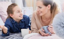 Mama i córka leżą na łóżku z herbatą i rozmawiają