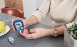 Kobieta sprawdza swój poziom cukru glukometrem