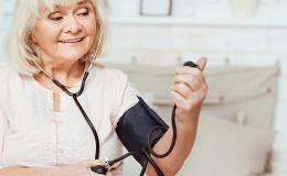 Starsza pani zadowolona z pomiaru ciśnienia