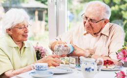 Starszy pan nalewa żonie wodę