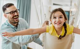 ojciec huśta dziewczynkę 