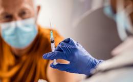 Starszy pan w maseczce czeka na szczepienie