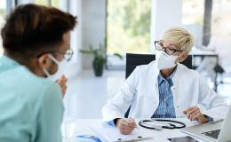 Lekarz w maseczce rozmawia z pacjentem