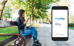 Kobieta na ławce w parku z telefonem w ręku, ekran z aplikacją obok