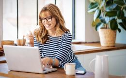 Kobieta w bluzce w paski przed komputerem 