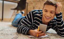 Młody mężczyzna patrzy na komórkę