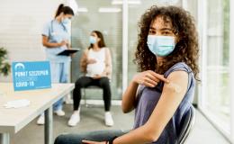 Dziewczyna pokazuje na plaster po szczepieniu