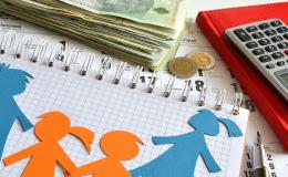 Na blacie leży zeszyt, pieniądze i kalkulator