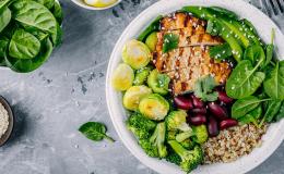 Talerz z jedzeniem, a na nim: brukselka, brokuł, szpinak, fasola, kasza i grillowana pierś kurczaka