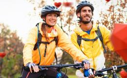 Para młodych ludzi na rowerach. Na głowach mają kaski. 