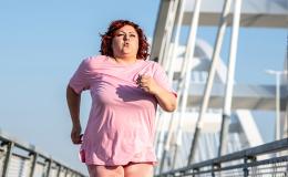 Biegnąca kobieta z nadwagą. W tle nowoczesny most