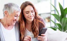 Wnuczka z babcią patrzą na komórkę