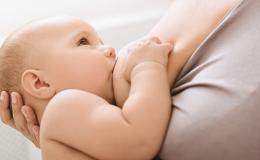 Bobas ssie mleko matki. Rączkę trzyma na jej piersi. 