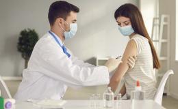 Młoda kobieta  w maseczce otrzymuje szczepionkę