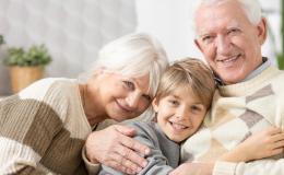 Przytuleni od lewej babcia, wnuczek, dziadek. Siedzą, patrzą na wprost.