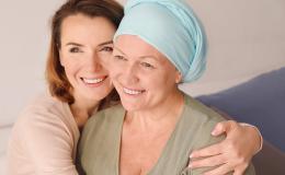 Młodsza kobieta obejmuje starszą, które głowa jest owinięta chustą