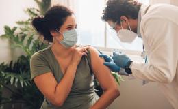 szczepienie młodej kobiety przez brodatego pielęgniarza