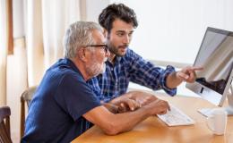 Młody mężczyzna pomaga starszemu wypełnić test