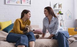 Matka z nastoletnią córką rozmawiają siedząc na tapczanie
