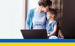 Matka przed komputerem całuje malucha w głowę