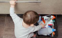 Bobas w łazience bawi się detergentami w koszyku. 