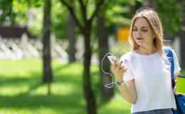 Kobieta na spacerze patrzy na komórkę