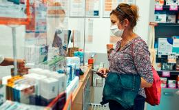 kobieta z komórką w aptece