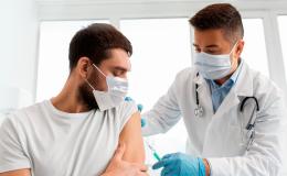 Pielęgniarz robi zastrzyk w ramię mężczyzny