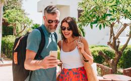 małzeństwo na urlopie patrzy na komórkę