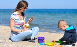 Matka z komórka, chłopiec, plaża