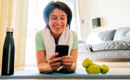 kobieta na macie patrzy na komórkę