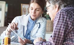 Lekarka omawia wyniki badań z pacjentem, który jest mężczyzna w 50 roku życia.