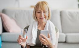 Kobieta po ćwiczeniach patrzy na telefon