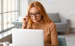 Kobieta w beżowym golfie przed komputerem