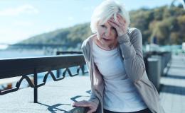 Starsza pani trzyma się za głowę