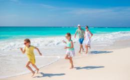 rodzina, dzieci biegną, rodzice za nimi, na plaży