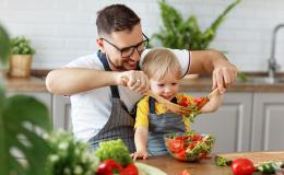 Tata z dzieckiem w kuchni robi sałatkę