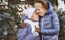 50latka przytula starszą panią, obie w kurtkach i czapkach