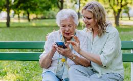 Mloda dziewczyna pokazuje seniorce coś na komórce