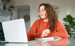 dziewczyna z długimi kręconymi włosami przed laptopem