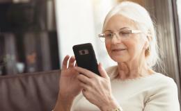 siwa pani z uśmiechem patrzy na telefon