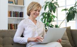 pani na kanapie z laptopem, w białej koszuli,