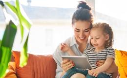 Mama z 2letnim dzieckiem na kanapie, trzyma tablet